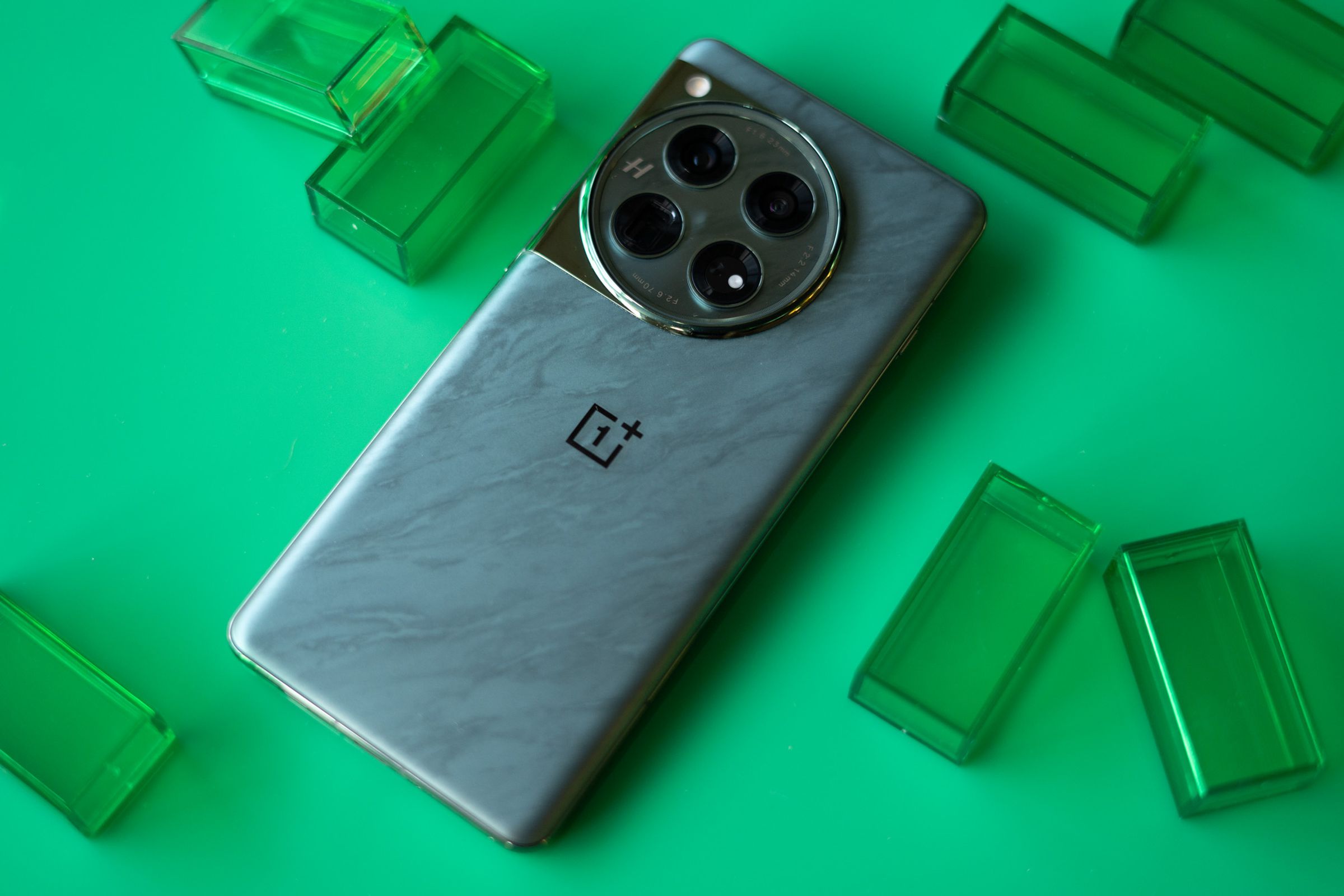 OnePlus 12 on a green background showing back panel of green color option.