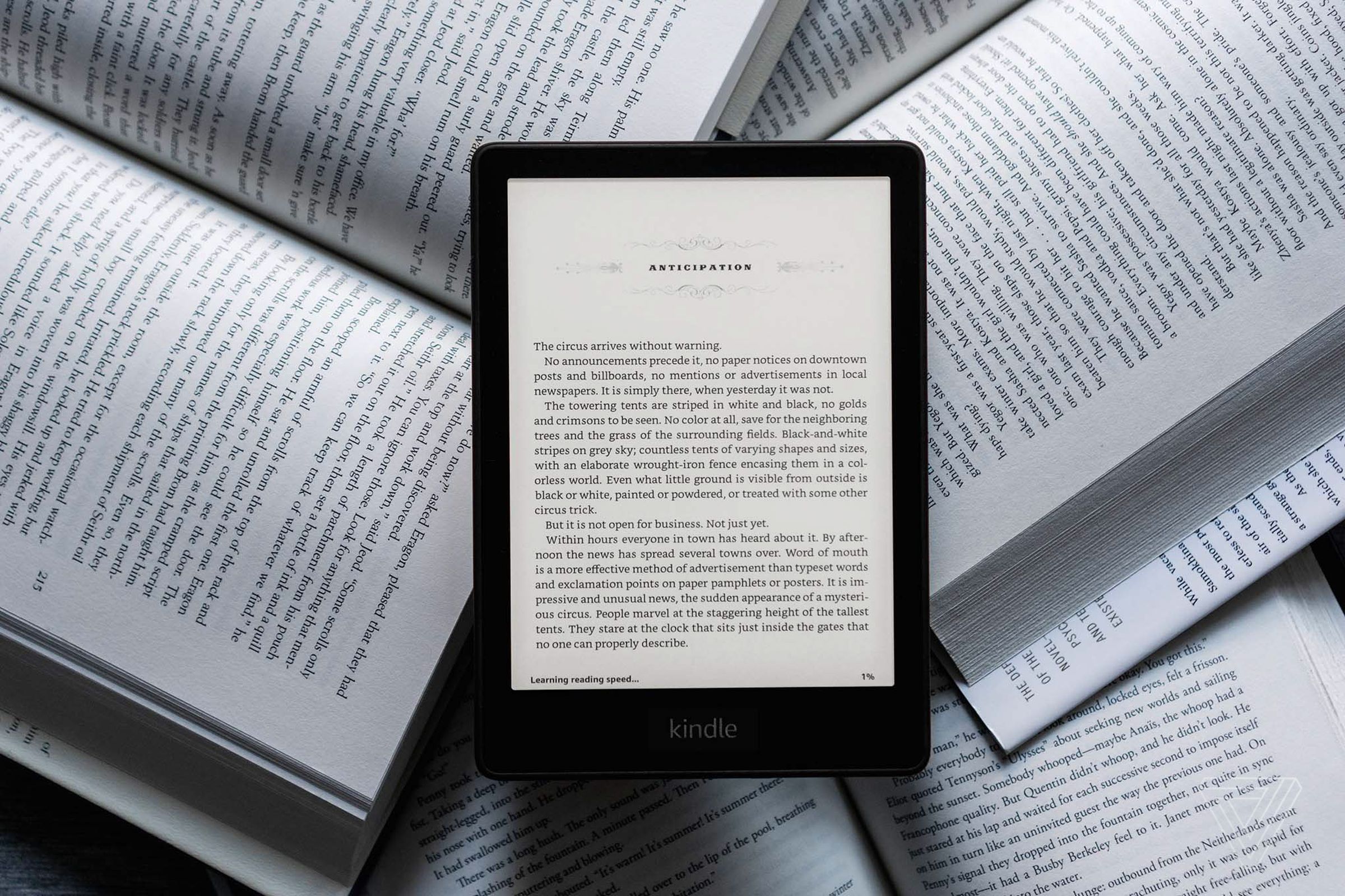 Το Kindle Paperwhite σε φόντο φυσικών βιβλίων.