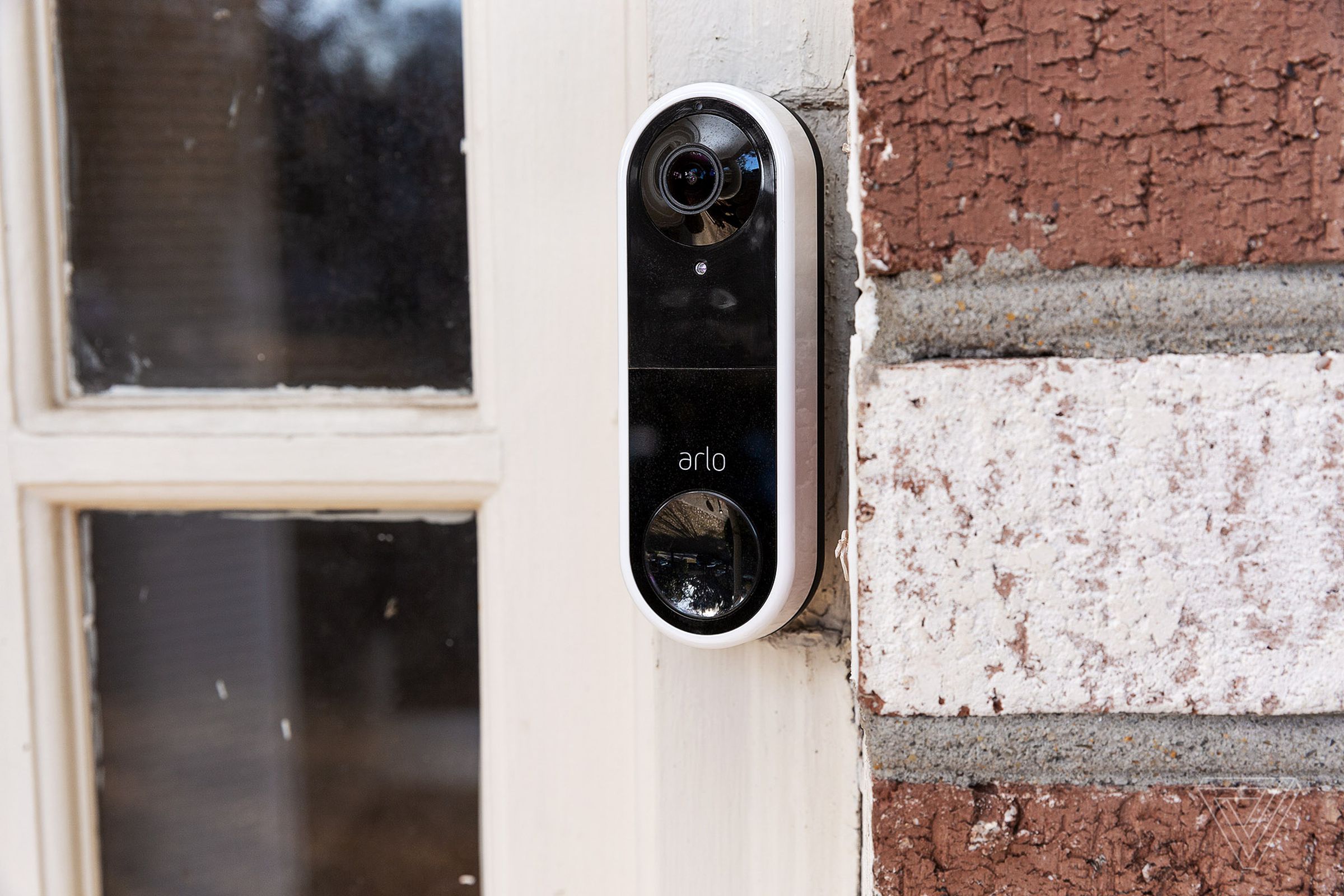 Arlo's Essential wired video doorbell installed on a front door.