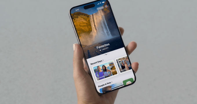 Η εφαρμογή Apple Photos ανανεώνεται για το iOS 18. Χέρι που κρατά ένα iPhone που εμφανίζει την εφαρμογή Φωτογραφίες