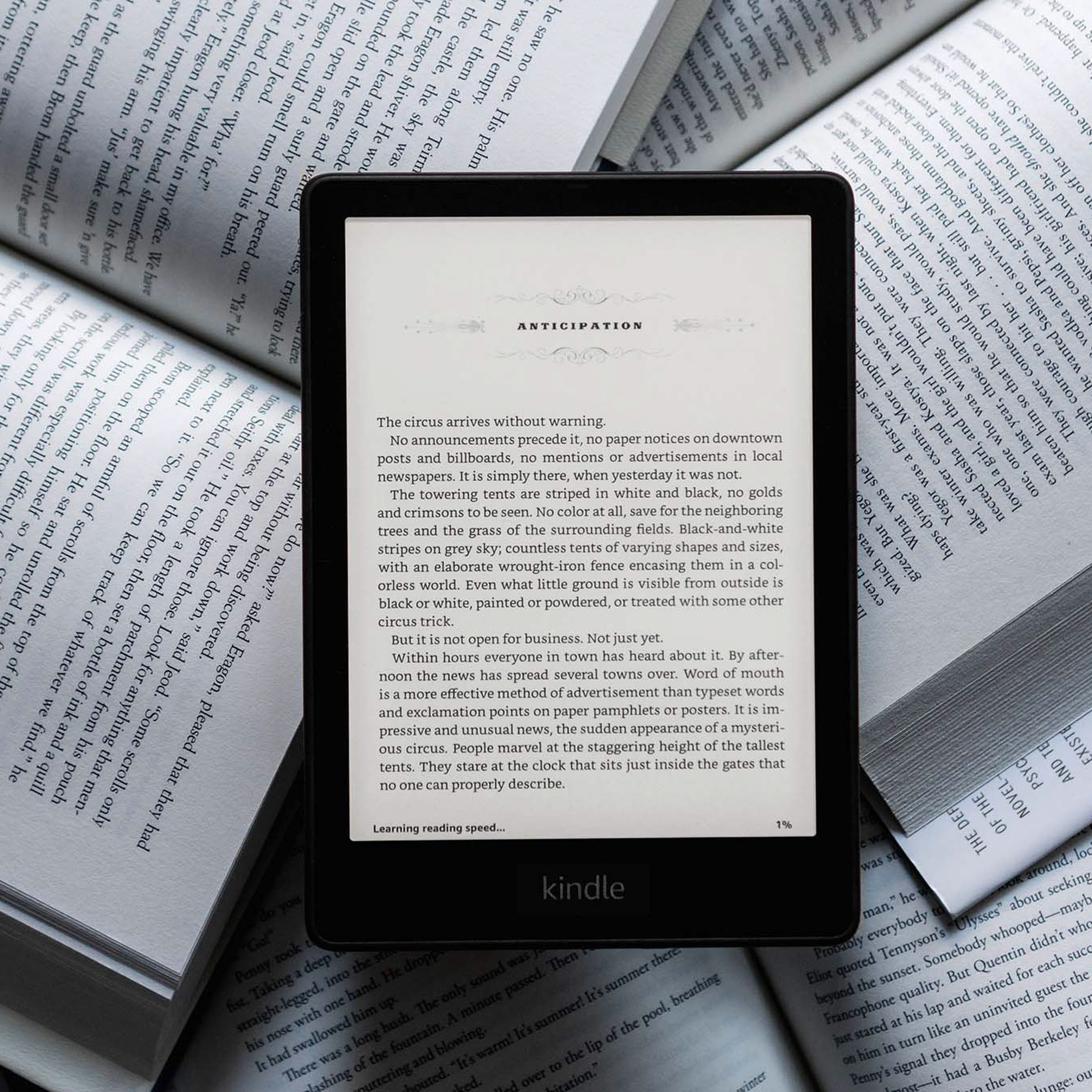 Το Kindle Paperwhite σε φόντο φυσικών βιβλίων.