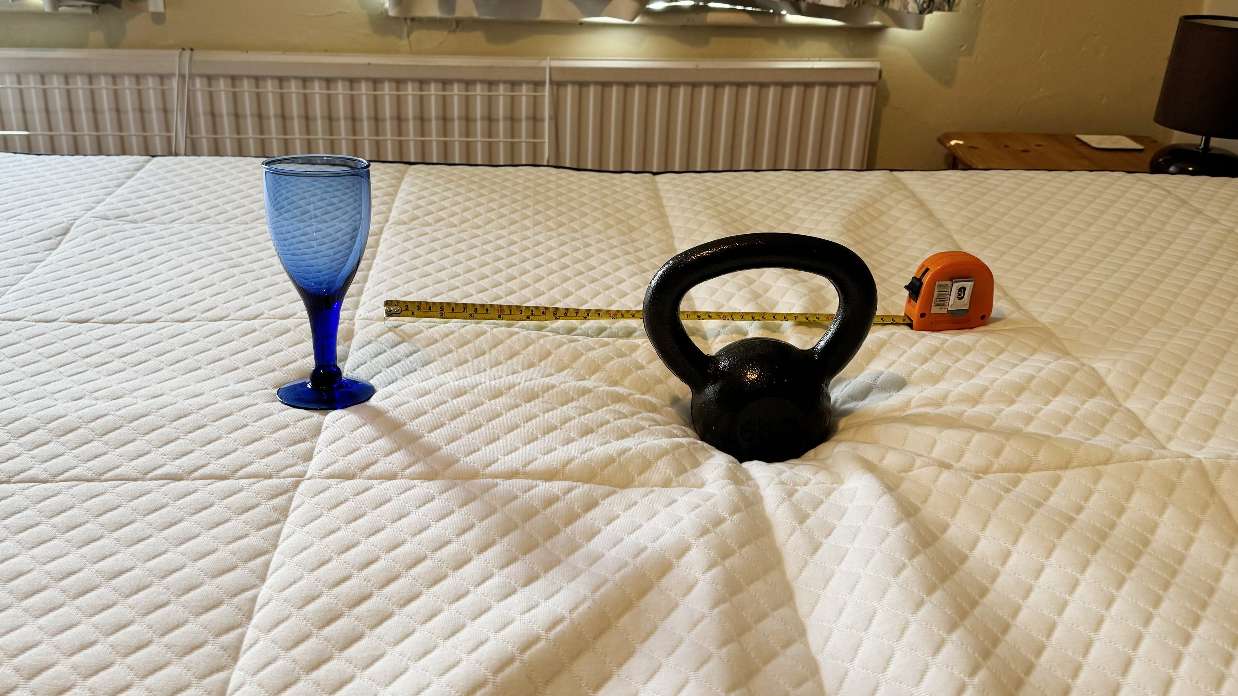 Testing the motion isolation of the Nectar Hybrid Mattress using an empty wine glass, 4kg weight and a tape measure.