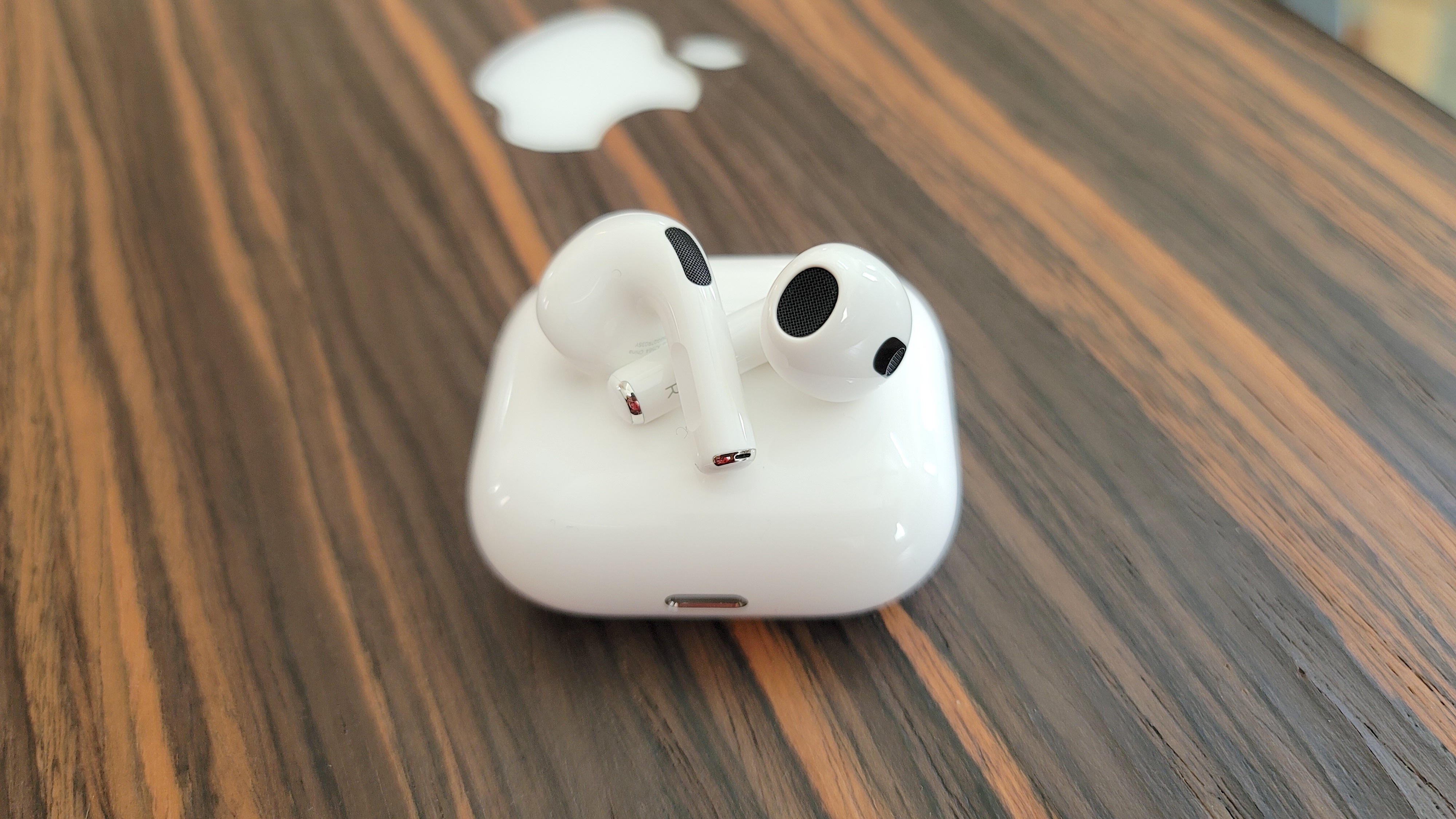 Τα ασύρματα ακουστικά Apple AirPods 3 βρίσκονται στο επάνω μέρος της θήκης ασύρματης φόρτισης