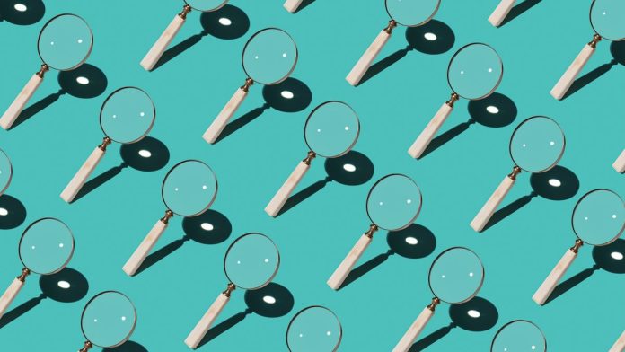 Repeating pattern of magnifying glasses on a turquoise background