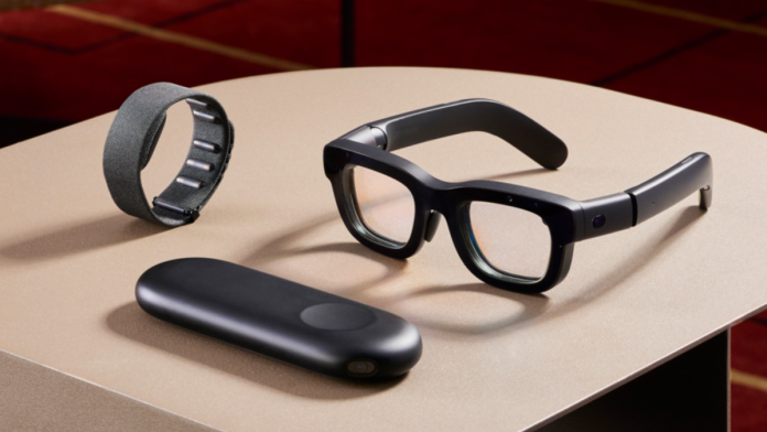 The Meta Orion glasses on a table next to a wristband and controller.