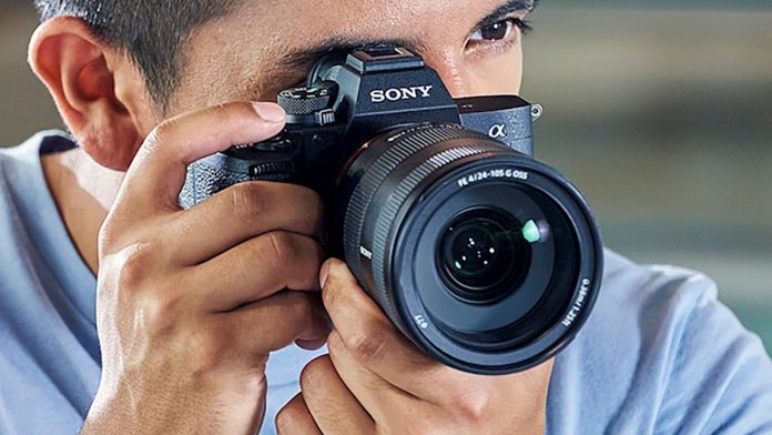 A man holding a Sony A7 IV camera up to his eye