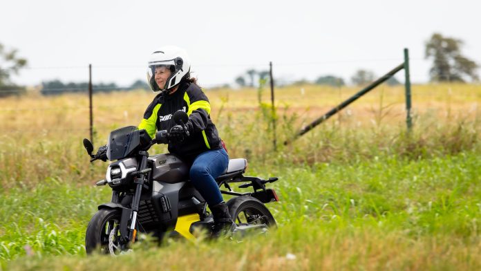 woman riding a motorcycle in a green field