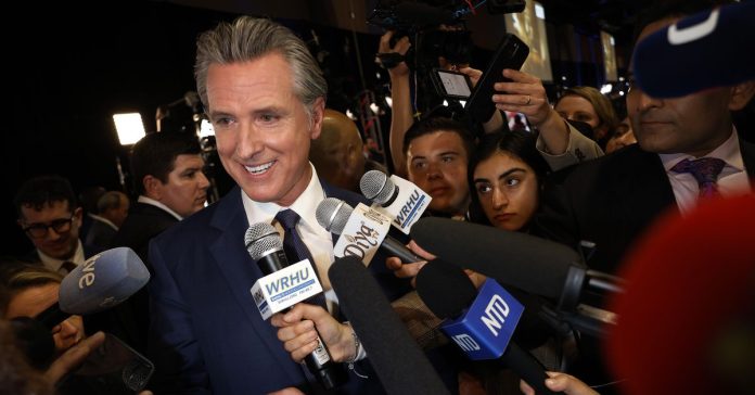 California Governor Gavin Newsom talks to journalists in the media center at the Pennsylvania Convention Center