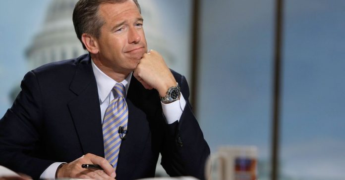 Brian Williams sitting at a desk, with his chin resting on his fist.